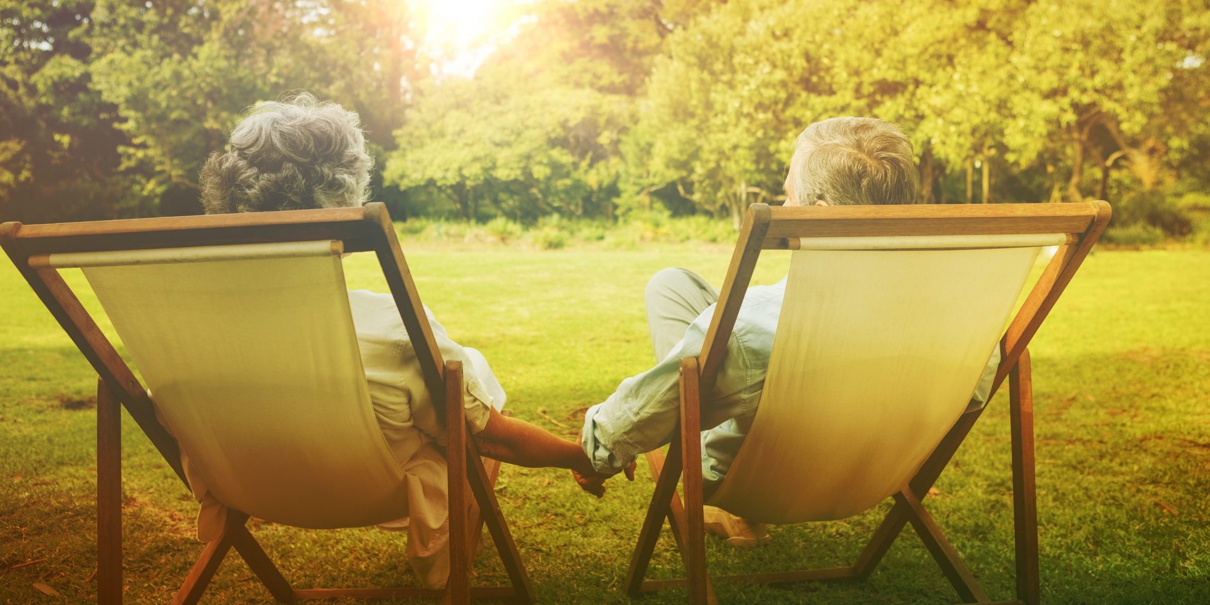 Happy mature couple sitting in park